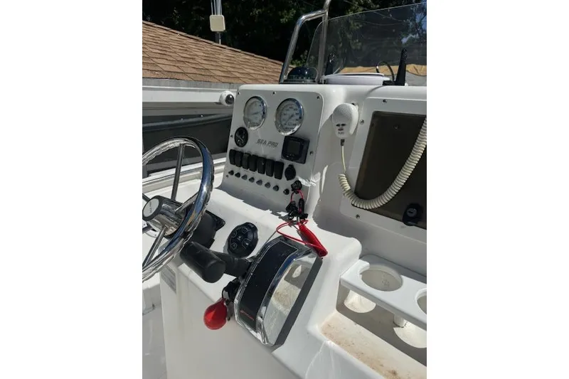 Slide: The Image of 2003 Sea Pro 206 Center Console boat dashboard with steering wheel and gauges. - 2
