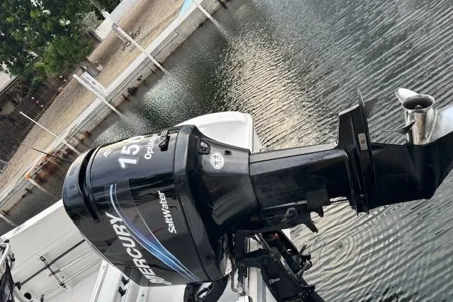 Slide: The Image of Mercury 150 outboard motor on 2003 Sea Pro 206 Center Console boat by a dock. - 5