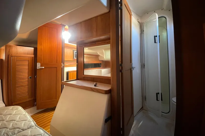 Slide: The Image of Interior of 2001 Catalina 380 yacht featuring wood cabinetry and compact bathroom. - 11