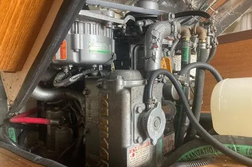 Slide: The Image of Engine compartment of a 2001 Catalina 380 sailboat, showcasing mechanical components and hoses. - 3