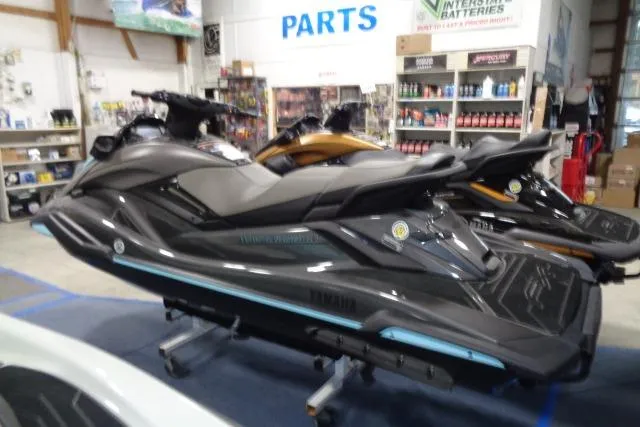 The Image of 2025 Yamaha WaveRunner FX HO jet ski displayed in a showroom with parts and accessories. - 0