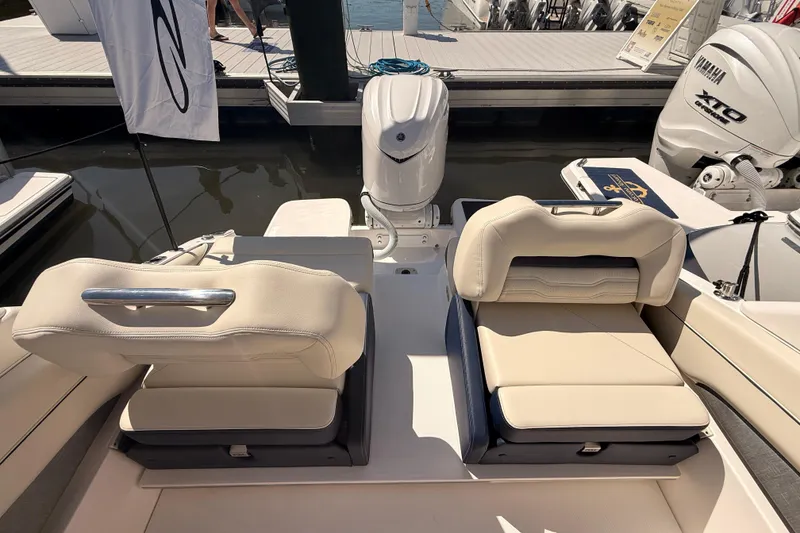 Slide: The Image of 2026 Regal LX6 boat with dual outboard engines, displayed outdoors near a white building. - 39