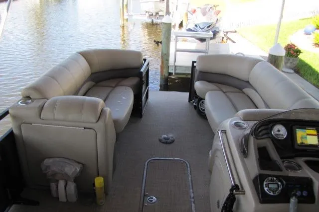 Slide: The Image of 2018 Regency 220 DL3 pontoon boat interior with plush seating and modern dashboard. - 12