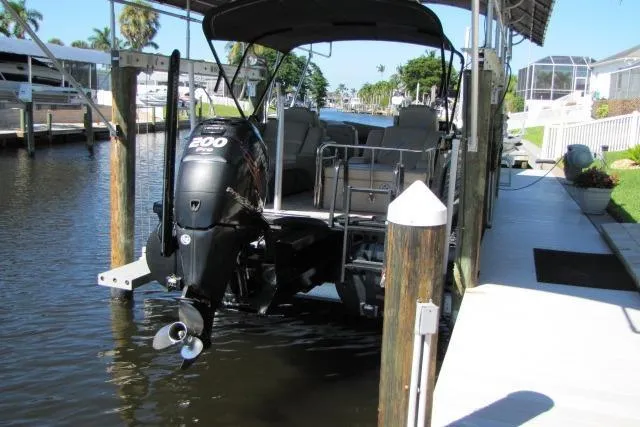 Slide: The Image of 2018 Regency 220 LE3 pontoon boat docked with 200 HP outboard motor. - 14