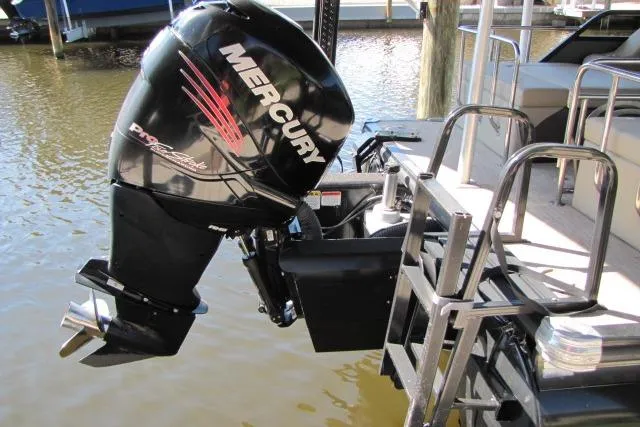 Slide: The Image of 2018 Regency 220 DL3 boat with Mercury outboard motor, docked on calm water. - 4