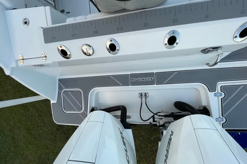 Slide: The Image of 2022 Blackfin 252 CC boat deck with dual Mercury engines and fishing rod holders. - 10
