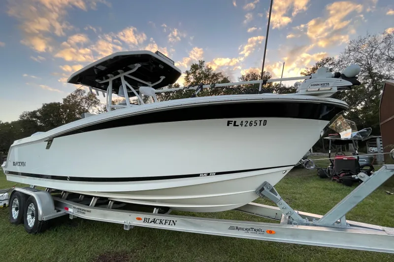 Slide: The Image of 2022 Blackfin 252 CC boat on trailer at sunset, showcasing sleek design. - 2