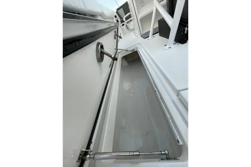 Slide: The Image of 2022 Blackfin 252 CC boat storage compartment with open hatch and hydraulic support. - 48