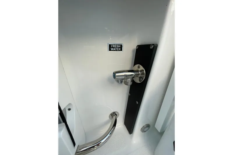 Slide: The Image of Freshwater outlet on 2022 Blackfin 252 CC boat, featuring sleek chrome finish. - 49