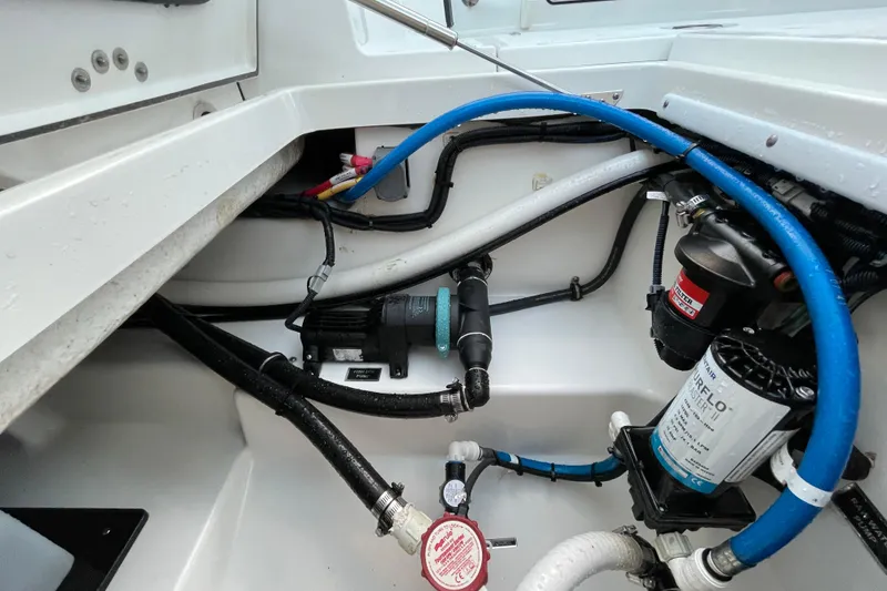 Slide: The Image of 2022 Blackfin 252 CC boat interior showing detailed wiring and plumbing system. - 52