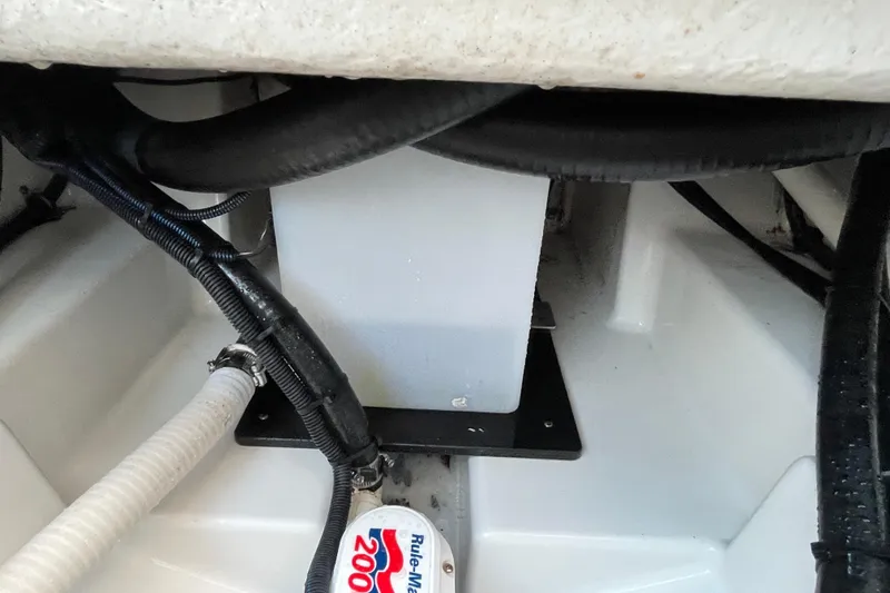 Slide: The Image of 2022 Blackfin 252 CC boat interior showing wiring and pump components. - 53