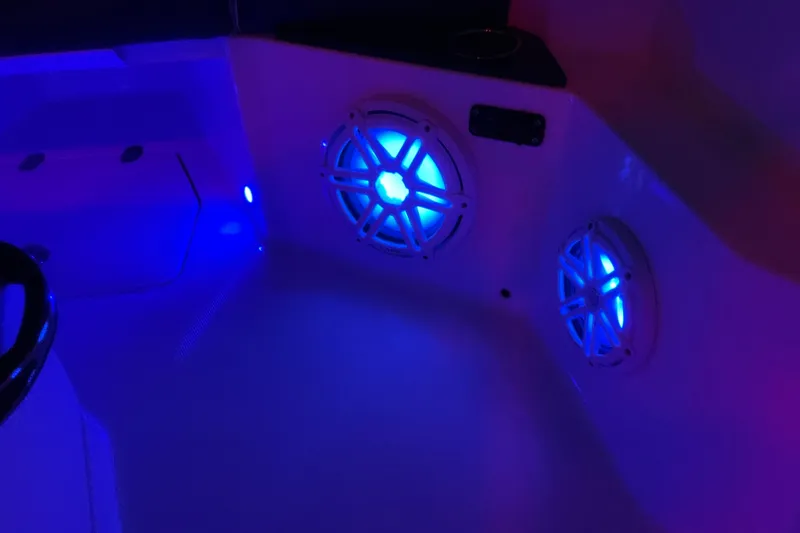 Slide: The Image of 2022 Blackfin 252 CC boat interior with illuminated blue speakers. - 55