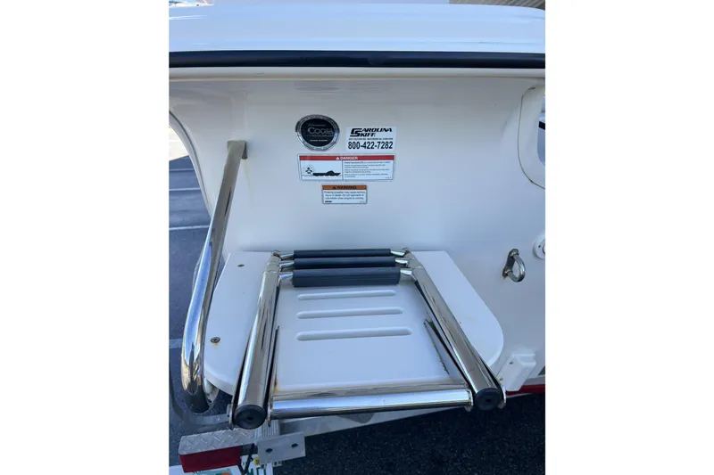 Slide: The Image of 2020 Carolina Skiff 21 LS boat ladder and safety labels on the stern. - 15