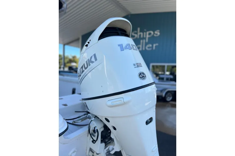Slide: The Image of 2020 Carolina Skiff 21 LS with Suzuki 140 outboard motor, displayed at a dealership. - 2