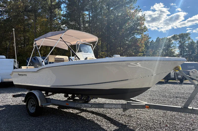 Slide: The Image of 2022 Tidewater 180 CC Adventure boat on trailer, parked outdoors under clear sky. - 4