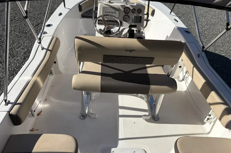 Slide: The Image of 2022 Tidewater 180 CC Adventure boat interior with beige seating and Garmin dashboard. - 6