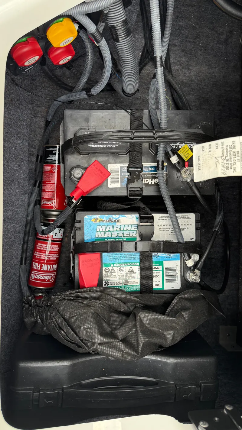 Slide: The Image of 2019 Yamaha AR240 boat battery compartment with marine batteries and wiring. - 7