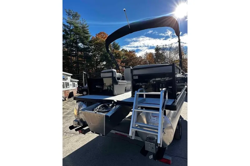 Slide: The Image of 2026 DOCKSIDE 20DQ boat with ladder, parked outdoors under sunny sky. - 3