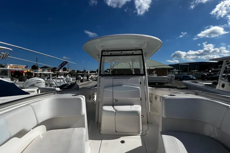 Slide: The Image of 2018 Robalo R302 Center Console boat under clear blue sky at marina. - 2