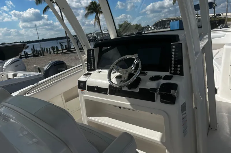 Slide: The Image of 2018 Robalo R302 Center Console boat helm with steering wheel and controls. - 3