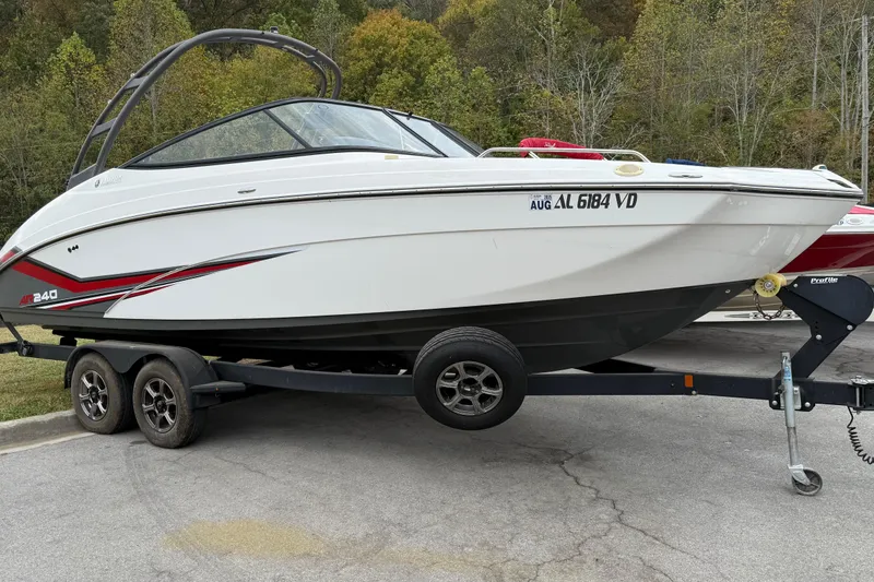 Slide: The Image of 2019 Yamaha AR240 boat on trailer, parked outdoors with forest background. - 1