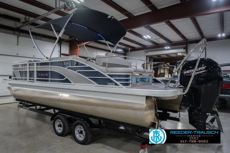 Slide: The Image of 2024 Bennington 23 LSB pontoon boat in showroom with Mercury outboard motor. - 10