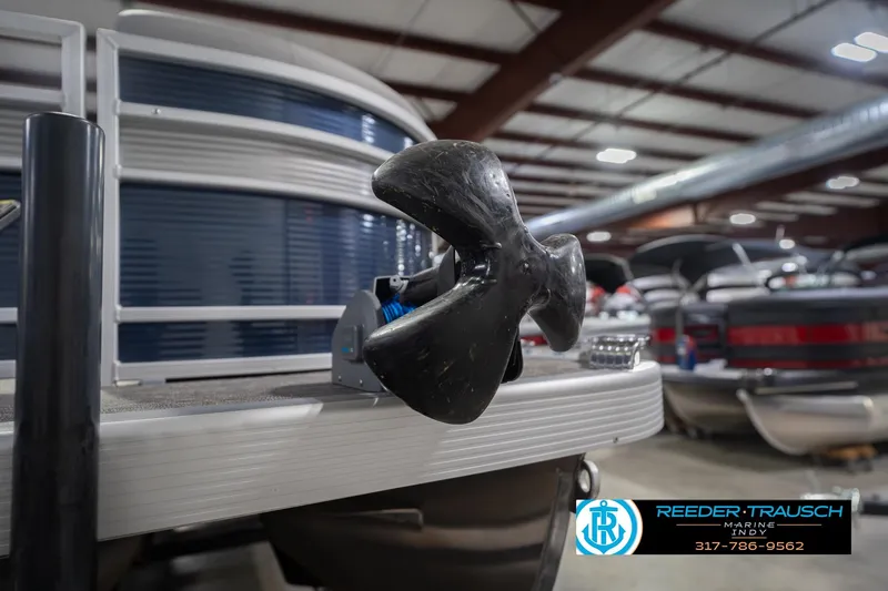 Slide: The Image of 2024 Bennington 23 LSB pontoon boat with a focus on the propeller in a showroom. - 64