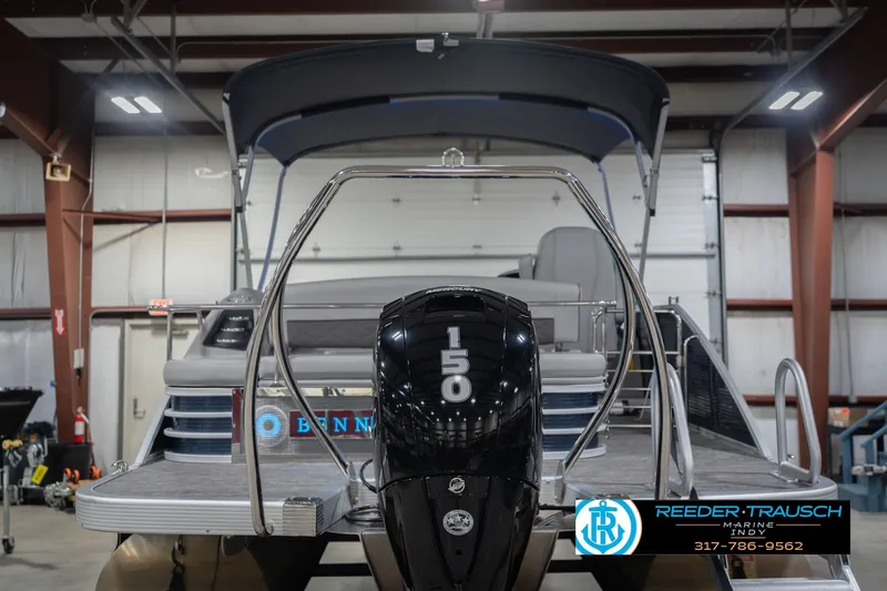 Slide: The Image of 2024 Bennington 23 LSB pontoon boat with 150 horsepower engine in a showroom. - 9