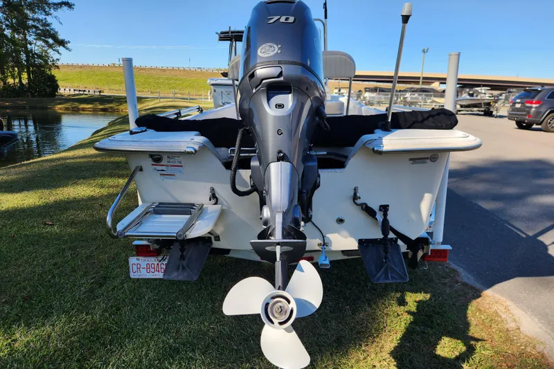 Slide: The Image of 2018 Carolina Skiff 18 JVX CC boat with outboard motor, parked near a lake. - 3