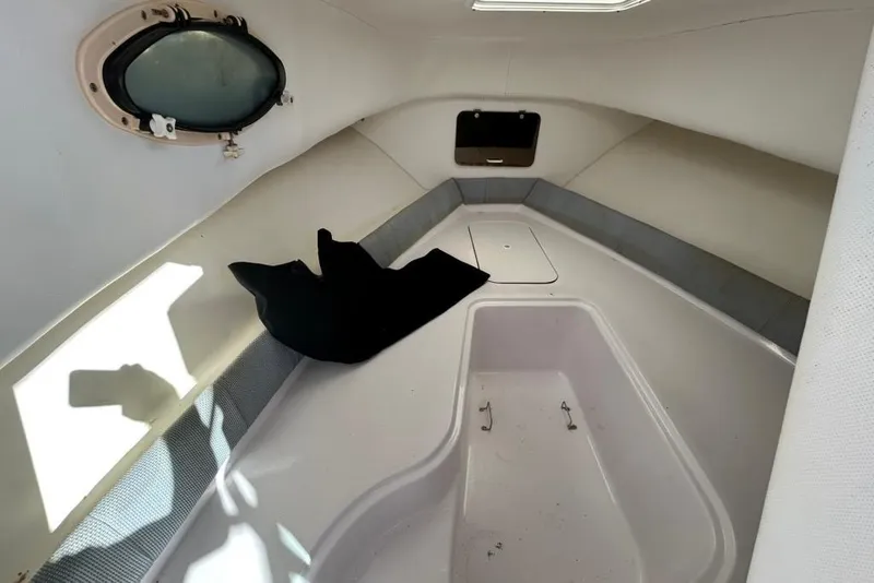 Slide: The Image of 2002 Pro-Line 22 Walk cabin interior with porthole and seating area. - 12