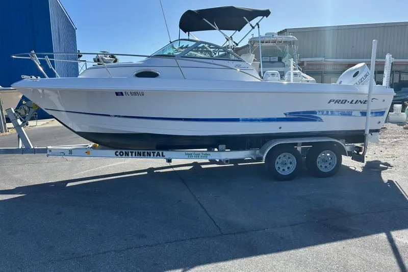 Slide: The Image of 2002 Pro-Line 22 Walk boat on a Continental trailer, parked outdoors. - 3