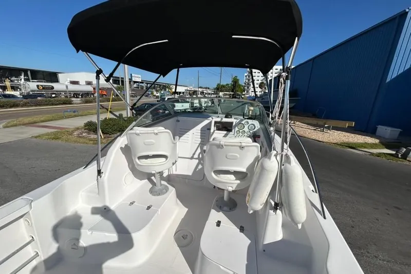 Slide: The Image of 2002 Pro-Line 22 Walk boat interior with seating and dashboard under canopy. - 7