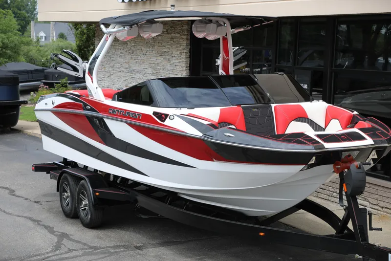 Slide: The Image of 2023 Centurion Fi25 boat with red, black, and white design on a trailer. - 17