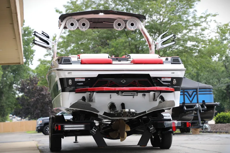 Slide: The Image of 2023 Centurion Fi25 boat on trailer, rear view with speakers and wakeboard racks. - 2