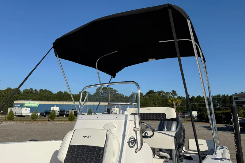 Slide: The Image of 2026 Tidewater 180 CC Adventure boat with canopy, parked outdoors under clear blue sky. - 9