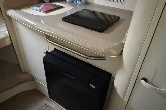 Slide: The Image of 1999 Sea Ray 270 Sundancer Special Edition interior kitchenette with countertop and mini fridge. - 10