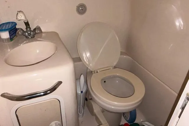 Slide: The Image of 1999 Sea Ray 270 Sundancer Special Edition bathroom with sink and toilet. - 13