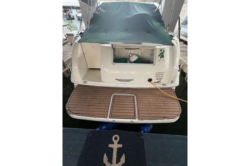 Slide: The Image of 1999 Sea Ray 270 Sundancer Special Edition docked with covered deck and anchor mat. - 2