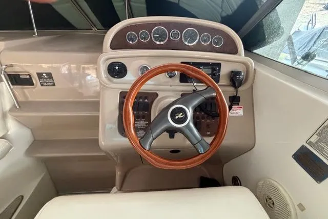 Slide: The Image of 1999 Sea Ray 270 Sundancer Special Edition helm with wood-accented steering wheel and instrument panel. - 6