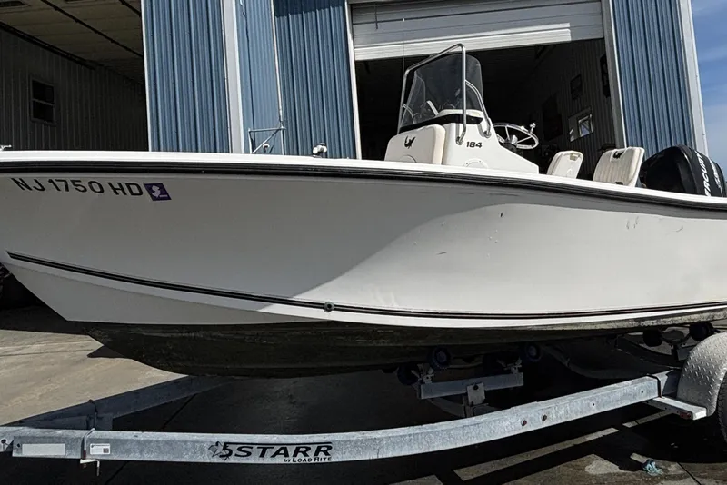 Slide: The Image of 2010 Mako 184 Center Console boat on trailer outside a blue building. - 0