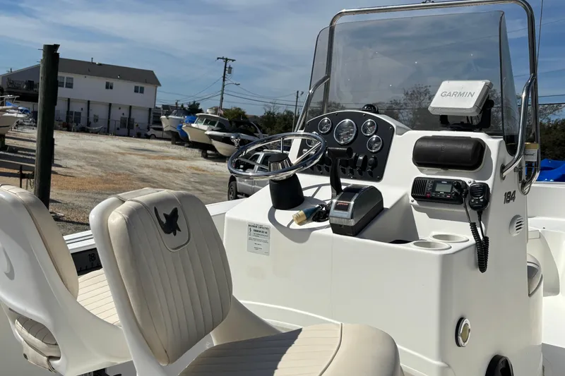Slide: The Image of 2010 Mako 184 Center Console boat with Garmin navigation, parked in a marina. - 1