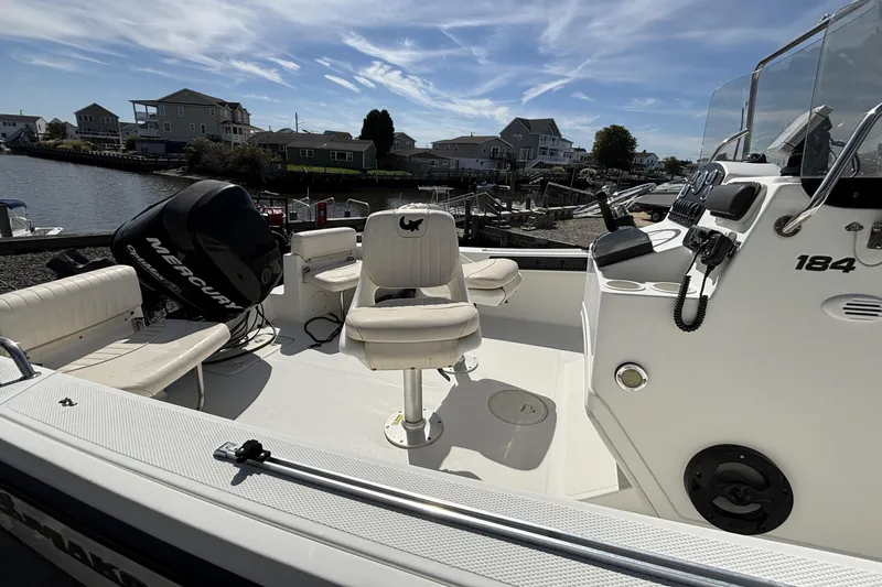 Slide: The Image of 2010 Mako 184 Center Console boat with Mercury engine, docked near waterfront homes. - 5