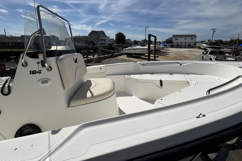 Slide: The Image of 2010 Mako 184 Center Console boat docked, featuring spacious seating and clear skies. - 6