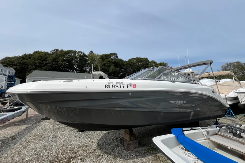 The Image of 2023 Hurricane SunDeck 235 OB boat on display, parked on gravel lot. - 0