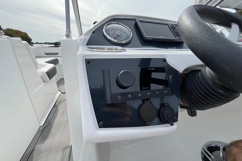 Slide: The Image of 2023 Hurricane SunDeck 235 OB boat dashboard with steering wheel and control panel. - 14