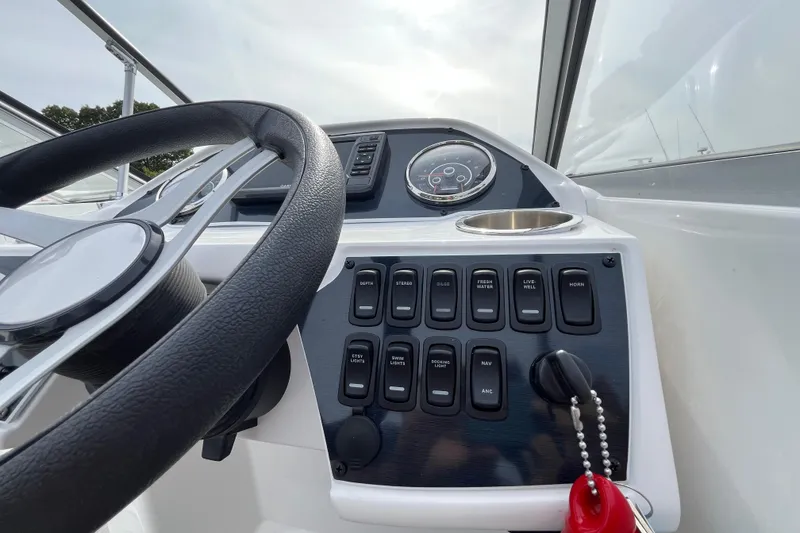 Slide: The Image of 2023 Hurricane SunDeck 235 OB boat dashboard with steering wheel and control panel. - 16