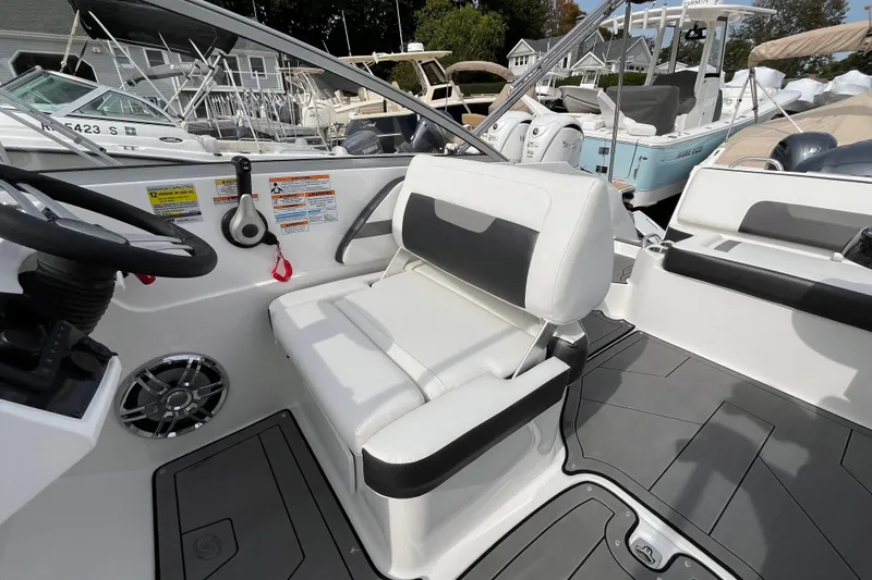 Slide: The Image of 2023 Hurricane SunDeck 235 OB boat interior with white seating and steering wheel. - 18