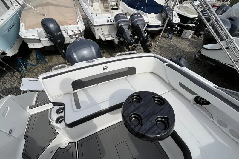Slide: The Image of 2023 Hurricane SunDeck 235 OB boat interior with seating and table, surrounded by other boats. - 22