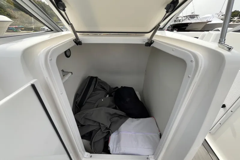 Slide: The Image of 2023 Hurricane SunDeck 235 OB storage compartment with gear inside. - 24