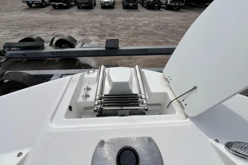 Slide: The Image of 2023 Hurricane SunDeck 235 OB boat ladder and storage compartment on trailer. - 29